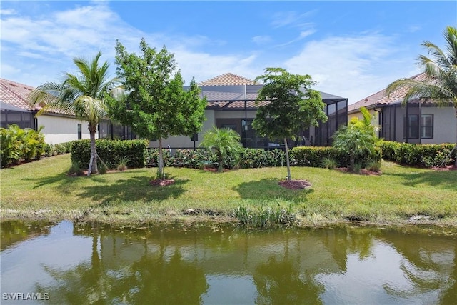 exterior space with a water view, a lanai, and a yard