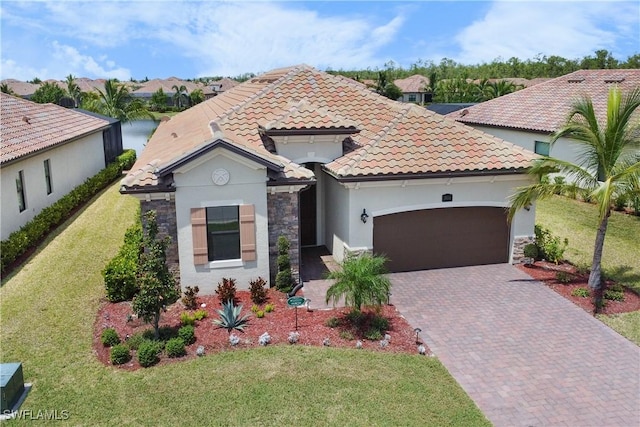 mediterranean / spanish-style house with a garage, a water view, and a front yard