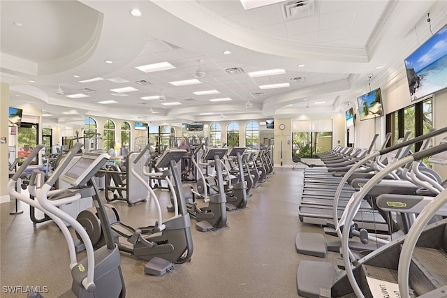 workout area with a paneled ceiling, a raised ceiling, and ornamental molding