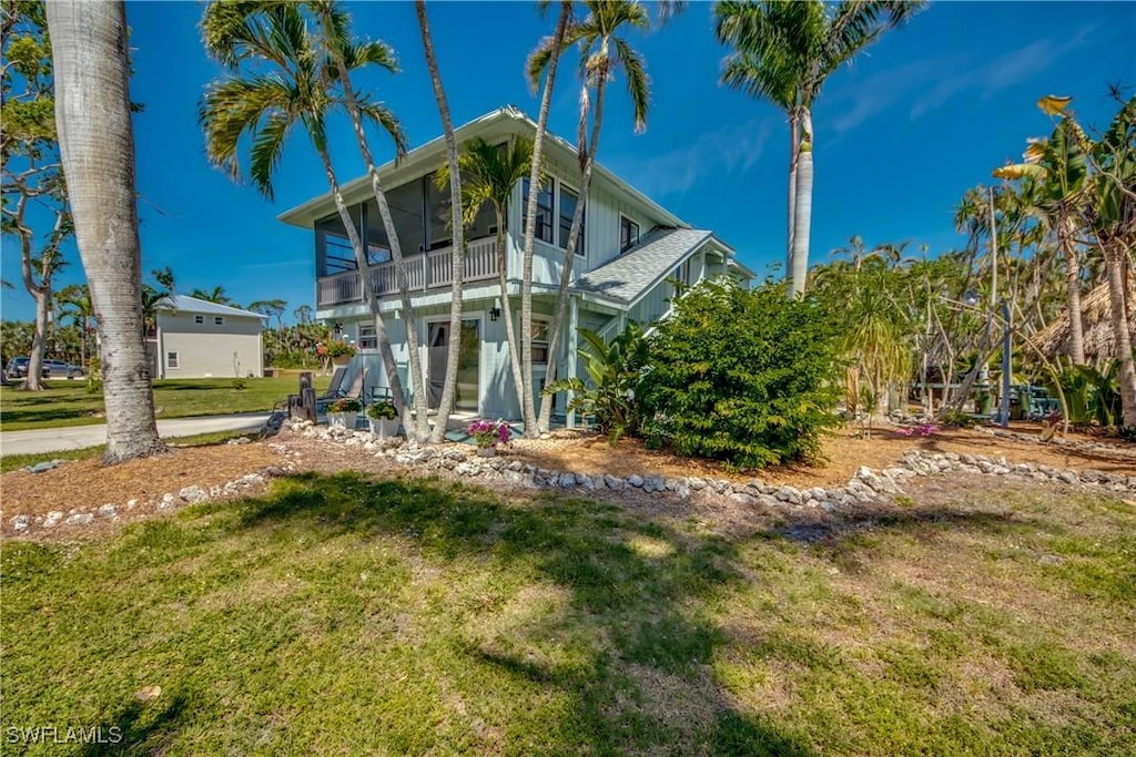 view of front of home with a sunroom and a front yard