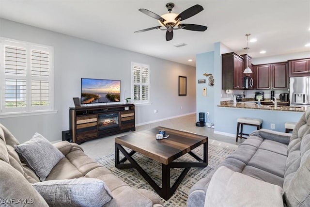 living room with a fireplace, light tile patterned floors, recessed lighting, a ceiling fan, and baseboards