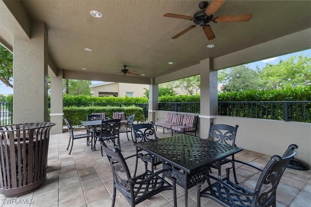 view of patio featuring outdoor dining space, ceiling fan, and fence