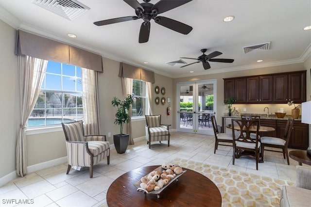 living area with a healthy amount of sunlight, visible vents, and crown molding