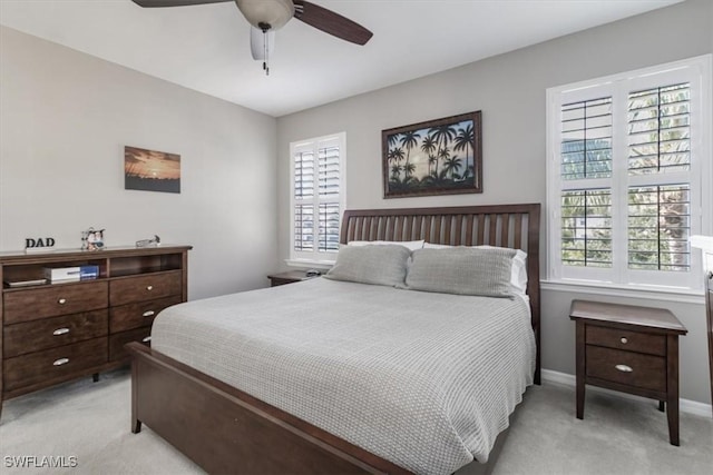 bedroom featuring baseboards, ceiling fan, and light colored carpet