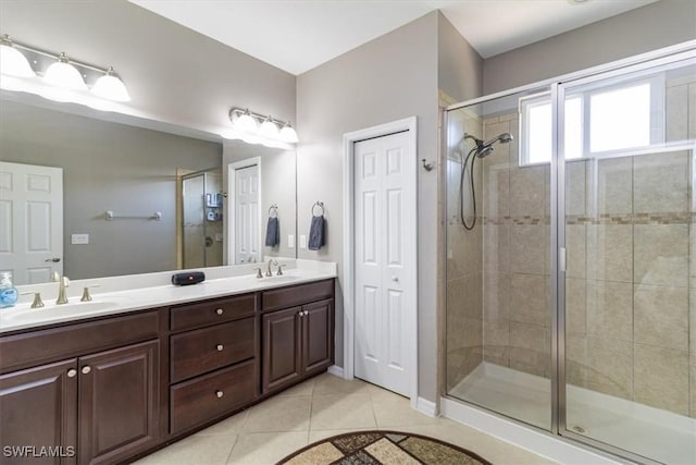 bathroom with double vanity, a stall shower, tile patterned flooring, and a sink