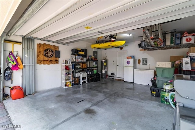 garage featuring electric water heater and freestanding refrigerator