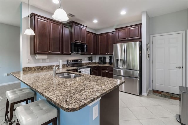 kitchen featuring a breakfast bar area, stainless steel appliances, visible vents, a sink, and a peninsula