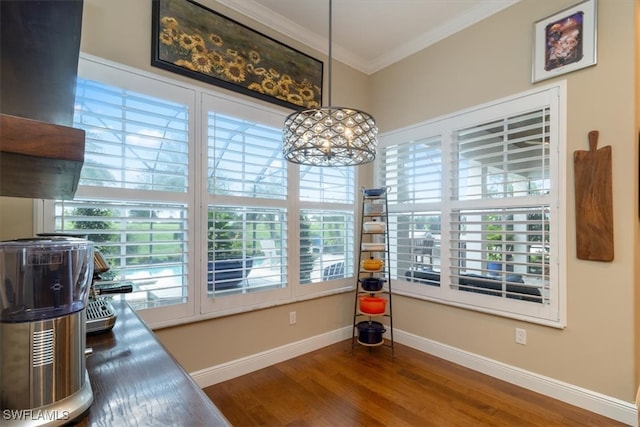 dining space featuring dark hardwood / wood-style floors, ornamental molding, and an inviting chandelier