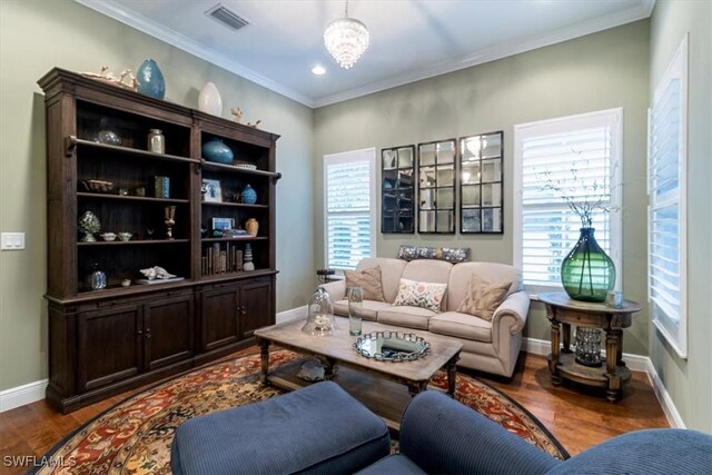 living room with a notable chandelier, dark hardwood / wood-style floors, and ornamental molding