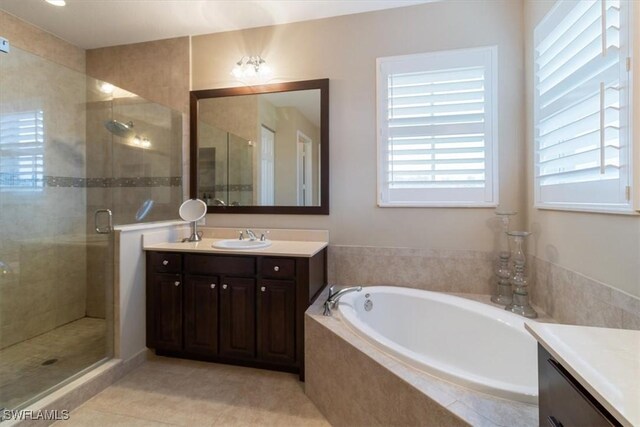 bathroom featuring tile patterned flooring, vanity, and separate shower and tub