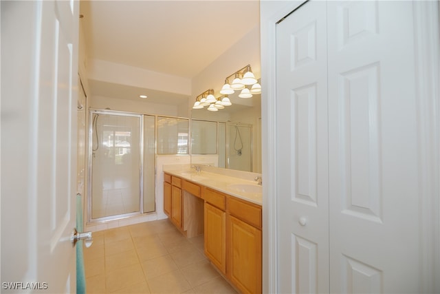 bathroom featuring tile patterned floors, double sink vanity, and a shower with shower door