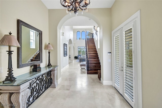 entrance foyer featuring a towering ceiling and a chandelier