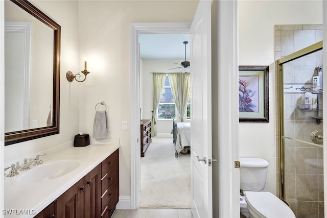 bathroom with ceiling fan, tile patterned flooring, toilet, vanity, and a shower with shower door