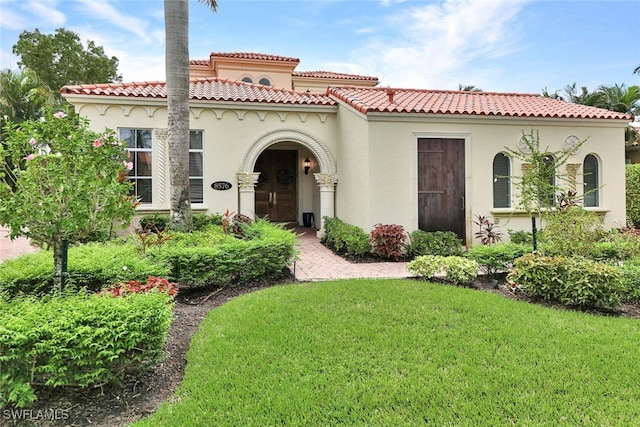 mediterranean / spanish-style home featuring a front lawn