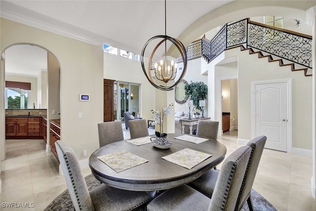 dining area featuring crown molding, sink, and a notable chandelier