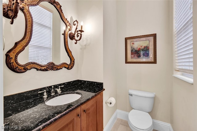 bathroom with tile patterned flooring, vanity, and toilet