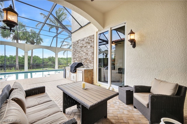 view of patio / terrace with area for grilling, a grill, an outdoor living space, and glass enclosure