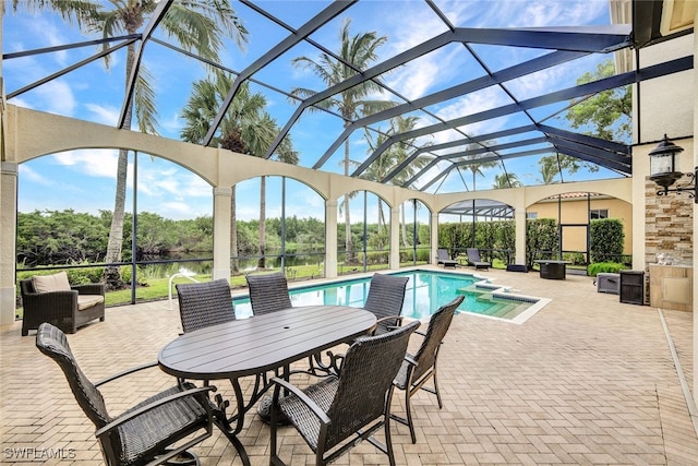 view of swimming pool with a lanai, a patio area, and a water view