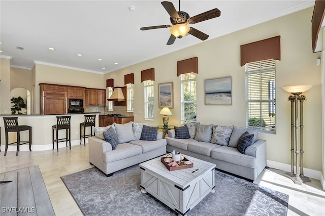 living room with ceiling fan and crown molding