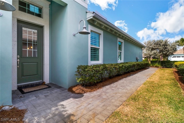 view of exterior entry with a lawn