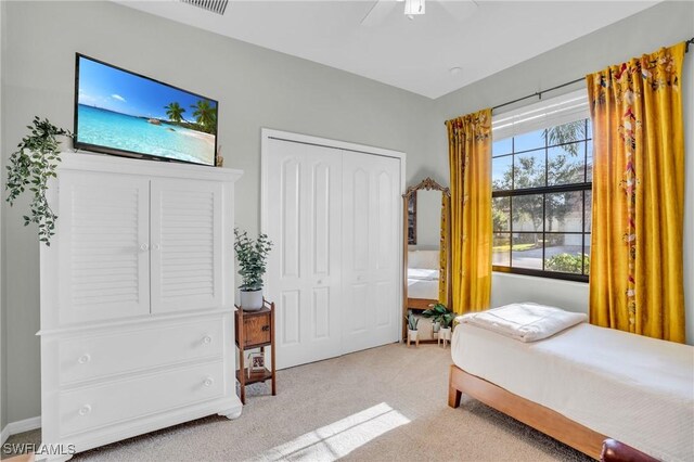 carpeted bedroom with ceiling fan and a closet