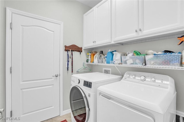 laundry area featuring cabinets, light tile patterned flooring, and washer and dryer