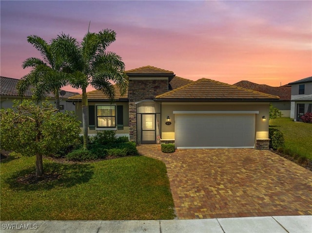 view of front of home featuring a garage and a lawn