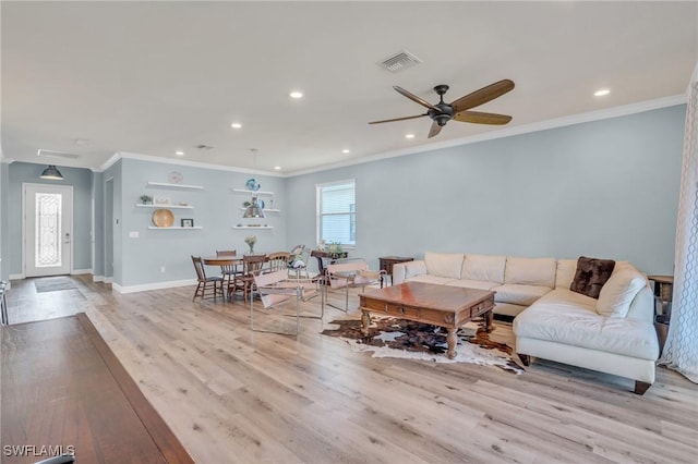 living room with crown molding, plenty of natural light, ceiling fan, and light wood-type flooring