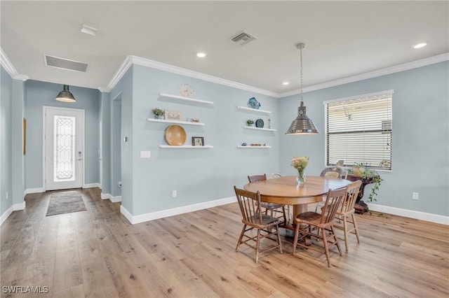 dining area with crown molding and light hardwood / wood-style floors