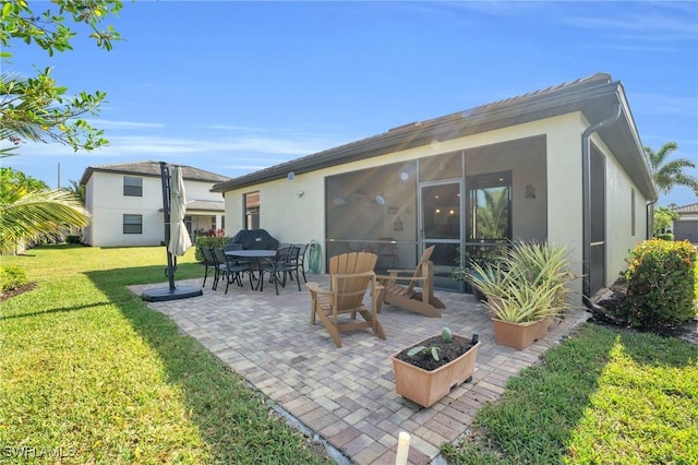 rear view of property with a yard and a patio area