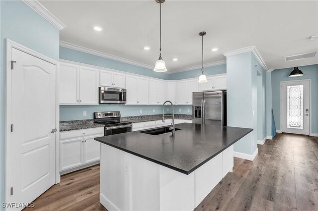 kitchen featuring appliances with stainless steel finishes, a kitchen island with sink, sink, and white cabinets