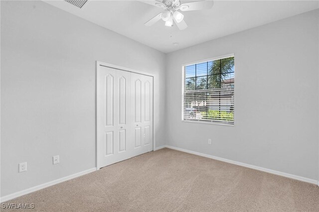 unfurnished bedroom with carpet floors, ceiling fan, and a closet