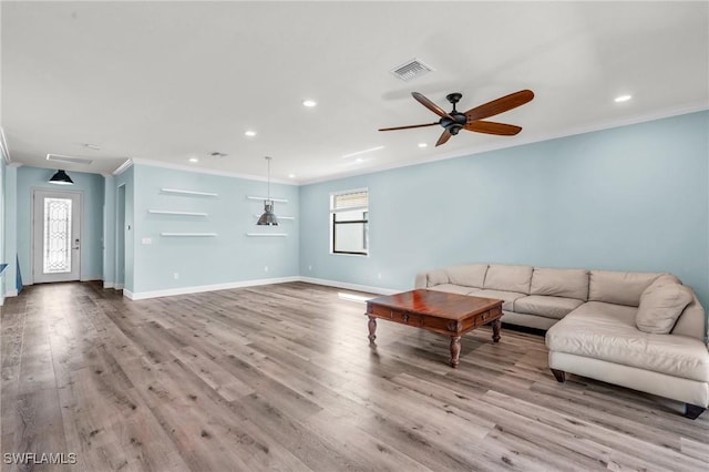 living room with ceiling fan, ornamental molding, light wood-type flooring, and a wealth of natural light