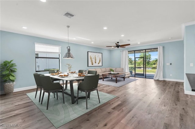 dining space featuring crown molding, light hardwood / wood-style floors, and ceiling fan