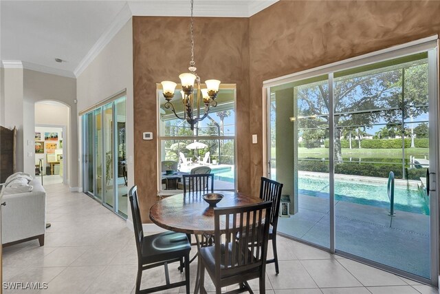 tiled dining room featuring a notable chandelier and ornamental molding