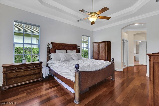 bedroom with ceiling fan, crown molding, dark hardwood / wood-style flooring, and a tray ceiling