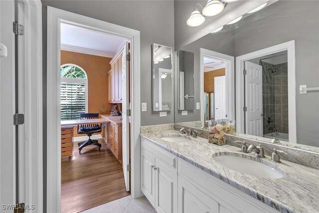 bathroom featuring tile patterned flooring, crown molding, tiled shower / bath combo, and dual vanity