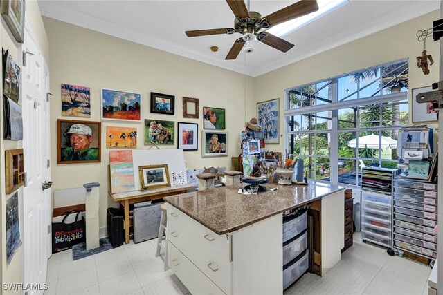 kitchen with white cabinetry, ornamental molding, light tile patterned floors, dark stone counters, and ceiling fan