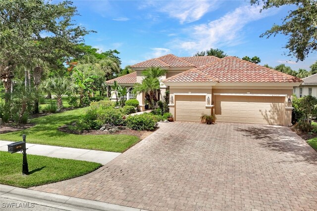 mediterranean / spanish home with a garage and a front yard