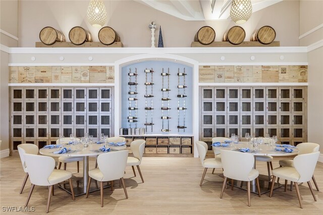 wine area featuring hardwood / wood-style flooring and a high ceiling