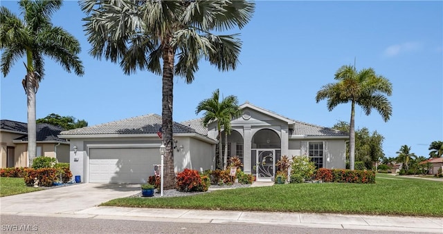 mediterranean / spanish house featuring a front lawn and a garage