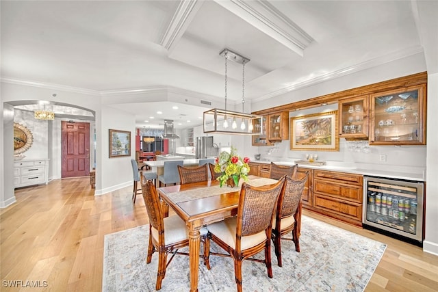 dining space featuring light hardwood / wood-style floors, wine cooler, and ornamental molding