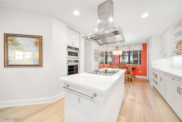 kitchen with island range hood, gas stovetop, pendant lighting, and white cabinets