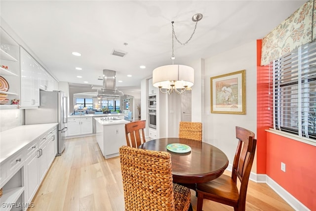 dining area featuring a notable chandelier and light wood-type flooring