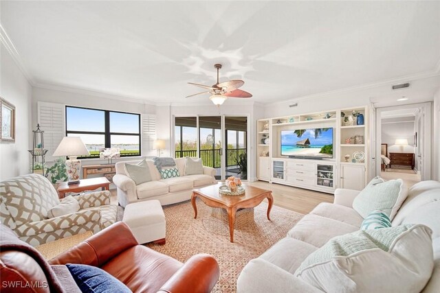 living room featuring a wealth of natural light, ceiling fan, ornamental molding, and light wood-type flooring