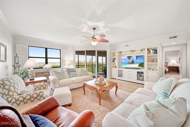 living room featuring ceiling fan, ornamental molding, and light hardwood / wood-style floors