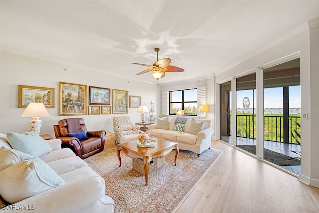 living room with light wood-type flooring, crown molding, and ceiling fan