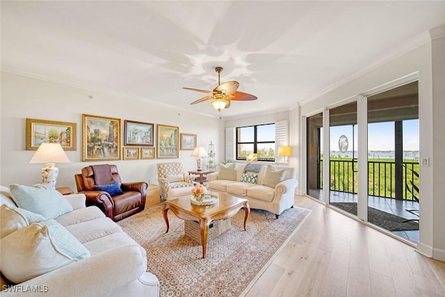 living room featuring ceiling fan, ornamental molding, and light hardwood / wood-style floors