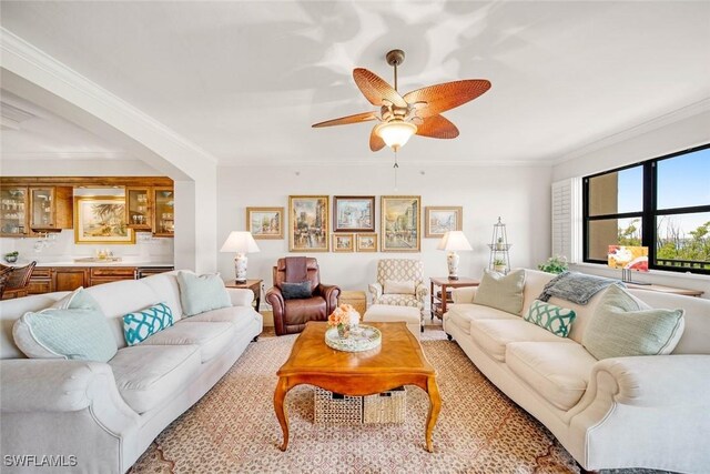 living room featuring ceiling fan and crown molding