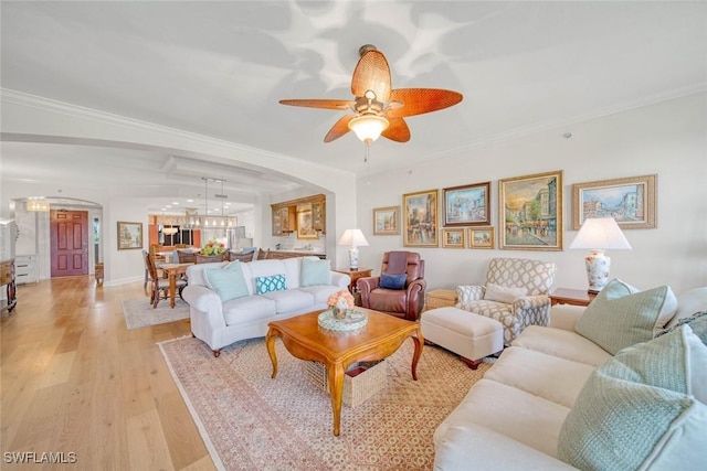 living room featuring light hardwood / wood-style floors, crown molding, and ceiling fan